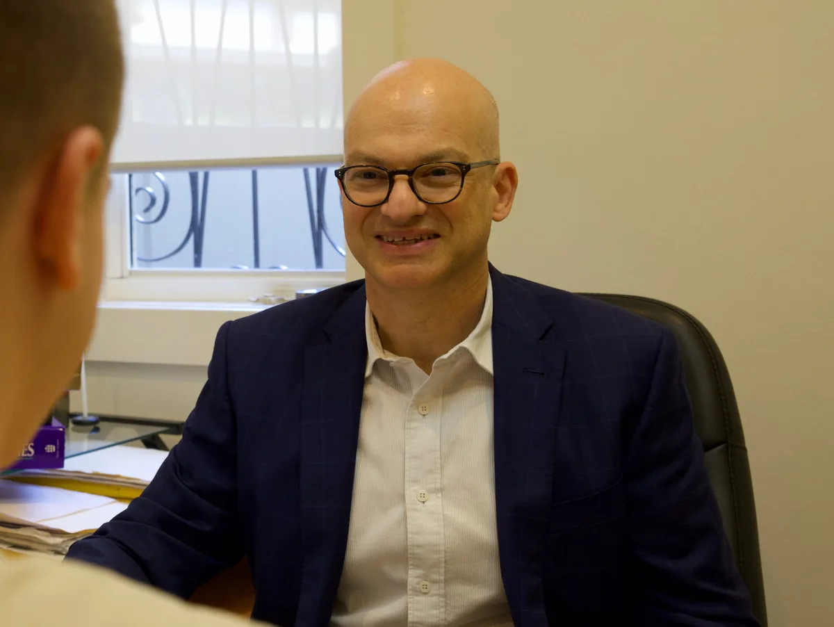 A/Prof Gary Galambos consulting with a patient at his desk
