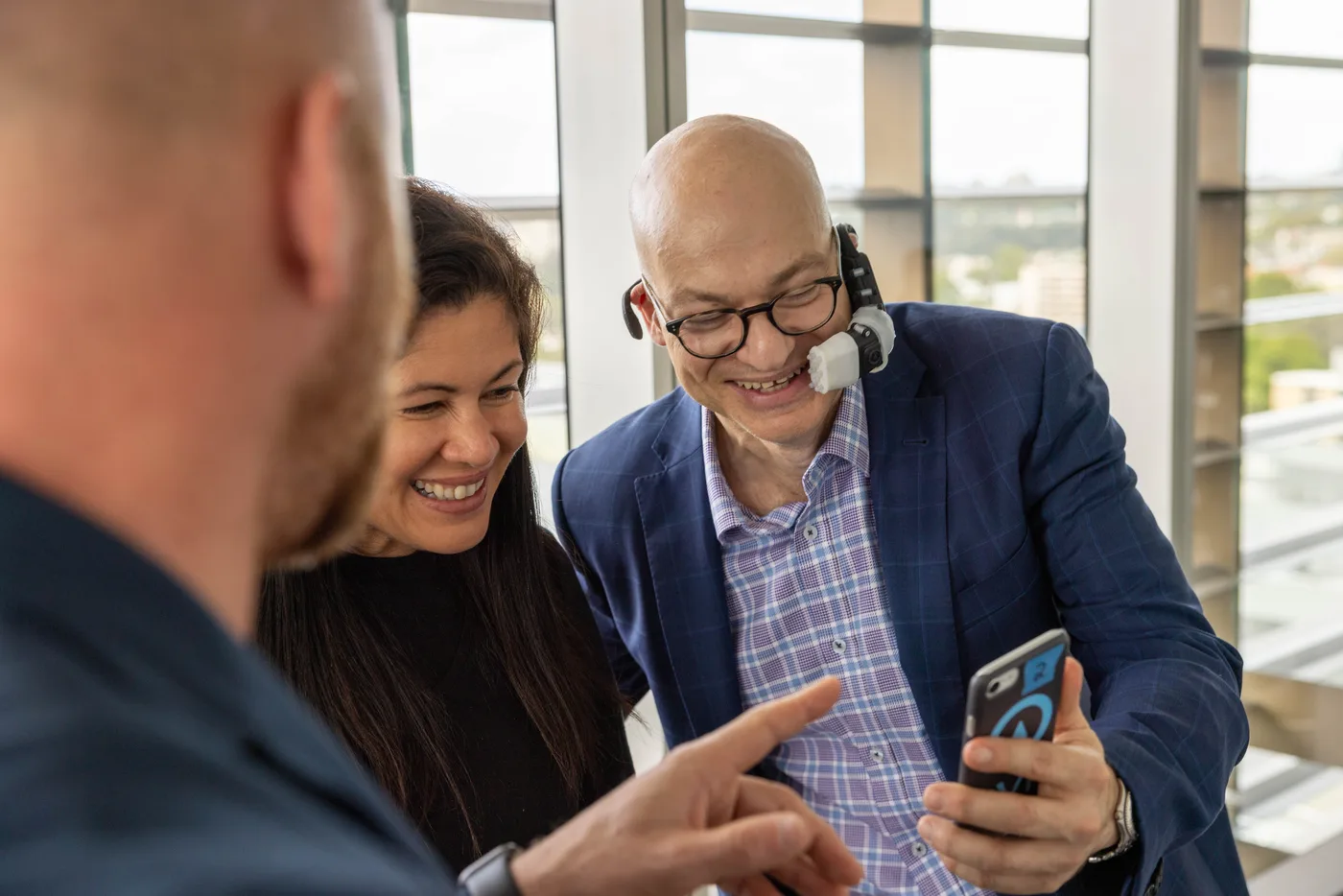 A/Prof Gary Galambos reviewing a mobile app with two colleagues