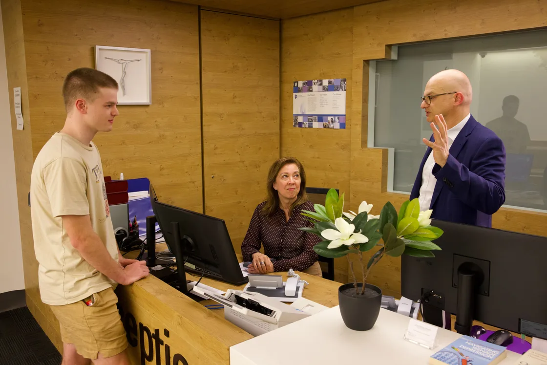 Clinicians talking with a young adult at the Uspace reception desk