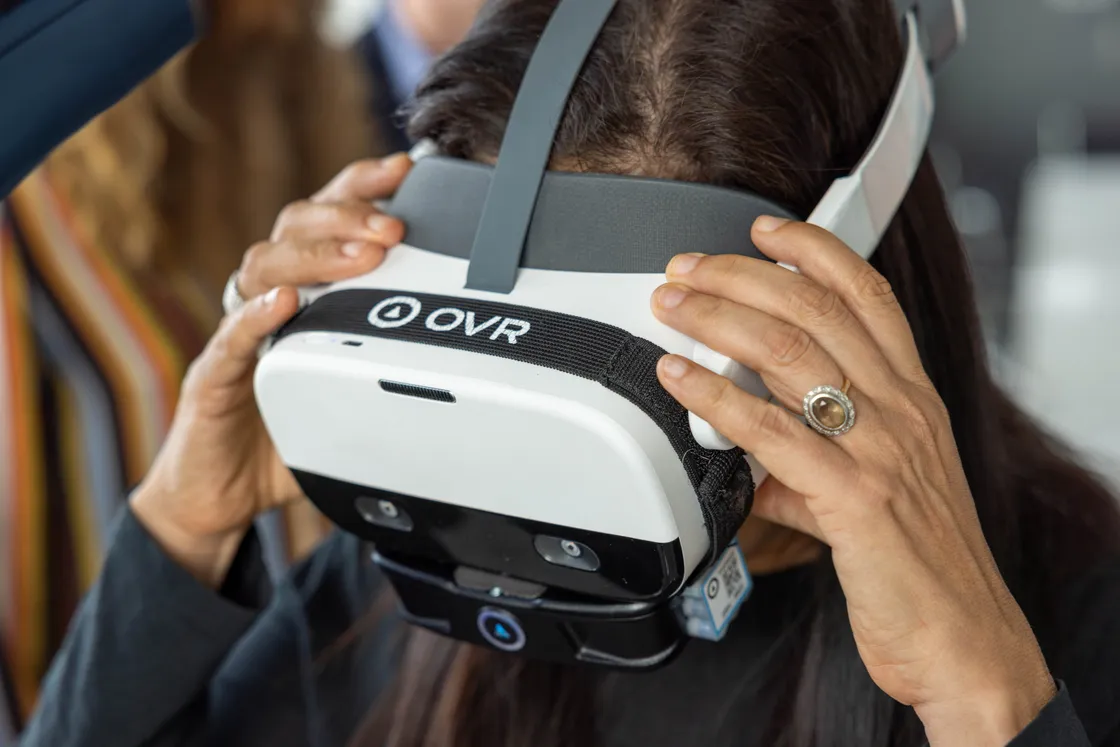 A clinician fitting a VR headset during a therapy session