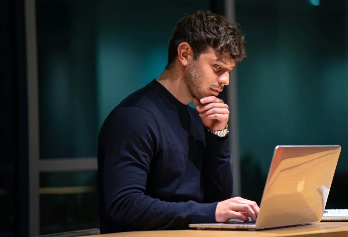 A person studying a MindSkiller® diagnosis unit on a laptop in a quiet, low-light setting